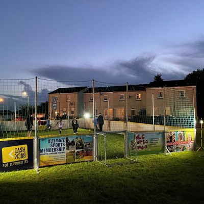 Young people playing street soccer at dusk in North Motherwell