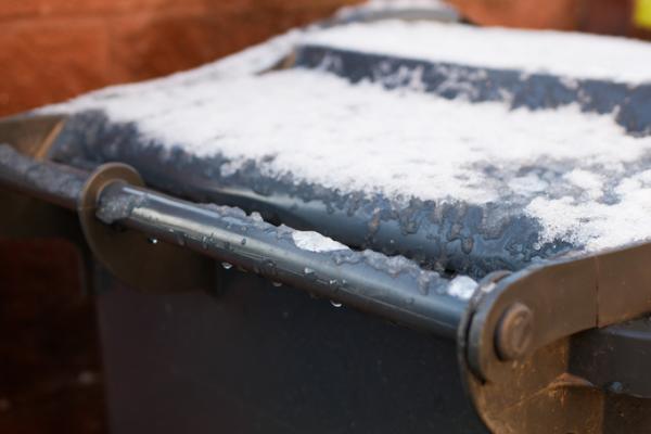 Grey bin with snow on lid